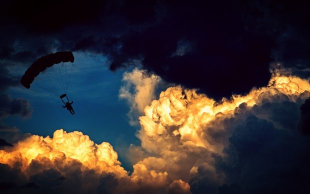 Skydiver jumping through clouds to display rediness for all eventualities