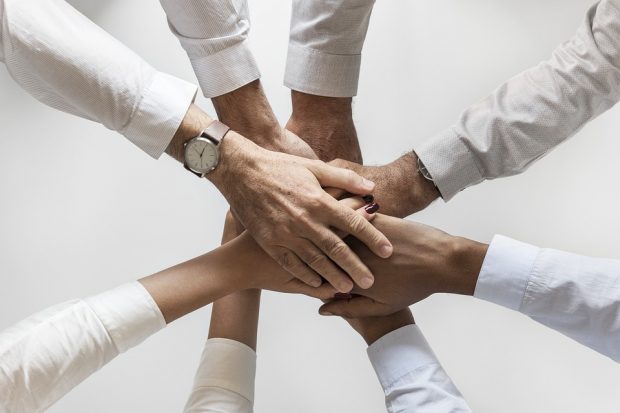 hands overlaid to convey group collaboration and achievement