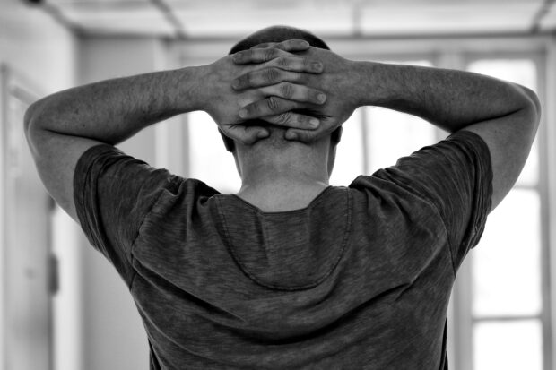 Man clasping his hands behind his head