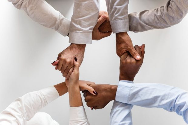 four pairs of joined hands symbolising unity